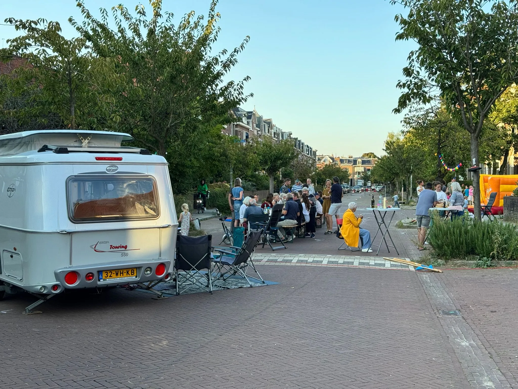 De Javastraat tijdens een eerder straatfeest: lange tafels midden op straat, buren aan tafel en een springkussen